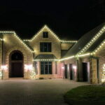 House with gold glowing holiday lights at night Class Act Glass Window Cleaning Mankato Minnesota